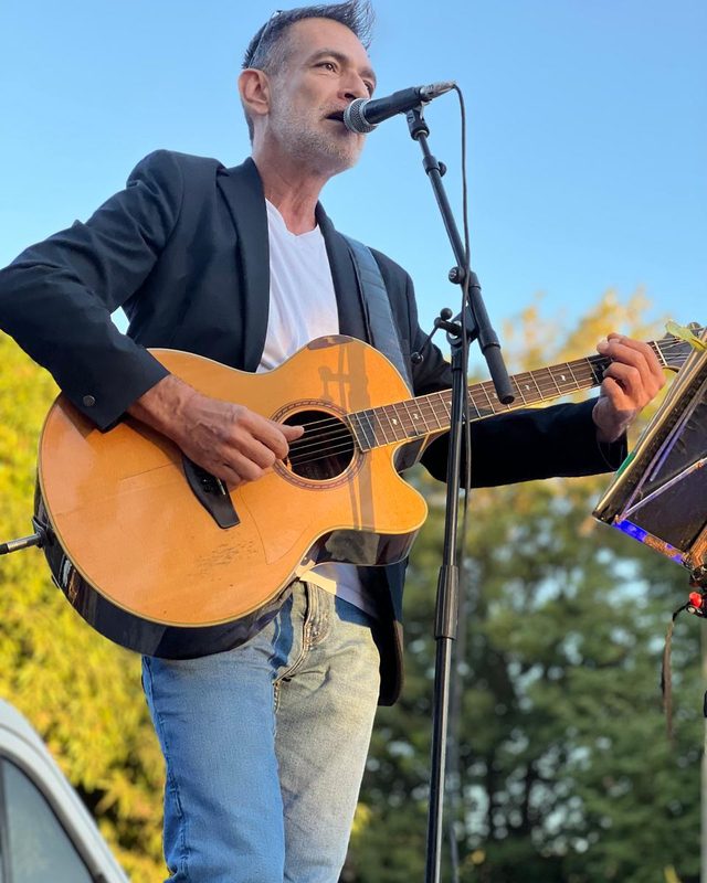 Guitariste en extérieur, ciel bleu